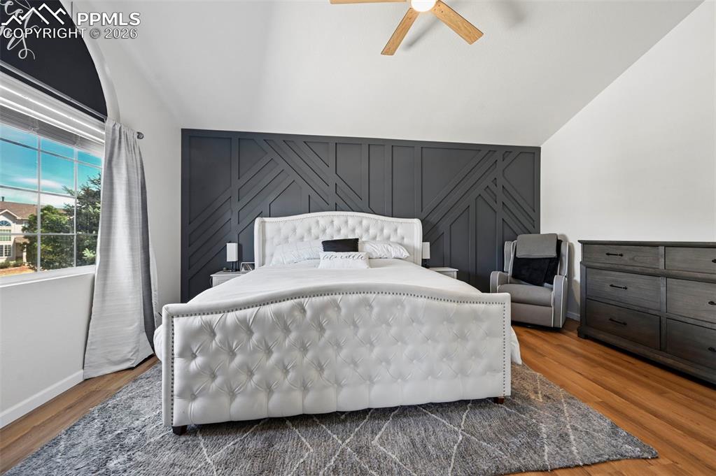 Image 37 of 45: This room features a decorative accent wall, a vaulted ceiling, and hardwoo