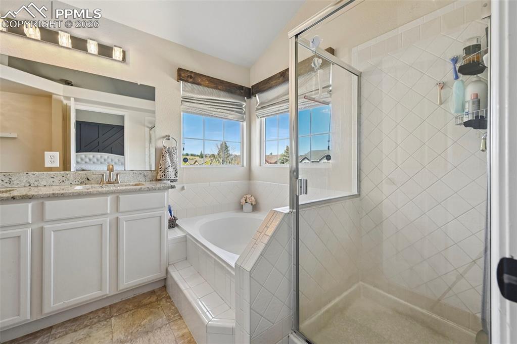 Image 39 of 45: Bathroom featuring a vanity with a granite countertop, a shower with a clea