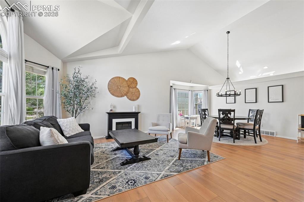 Image 4 of 45: This inviting living space features vaulted ceilings, wood laminate floorin