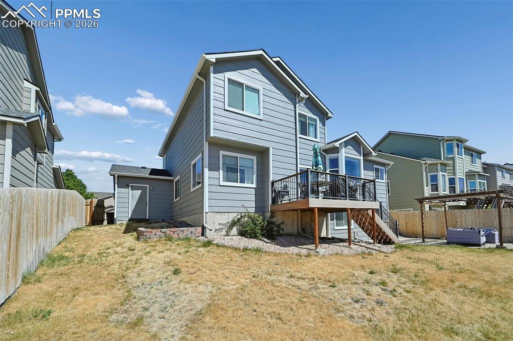 Image 45 of 45: The property features a back deck with dark railings and stairs