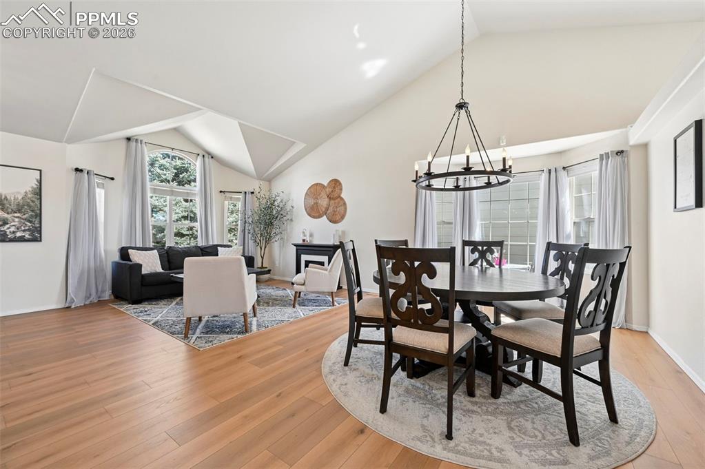 Image 7 of 45: Bright living and dining areas featuring vaulted ceilings, large windows wi