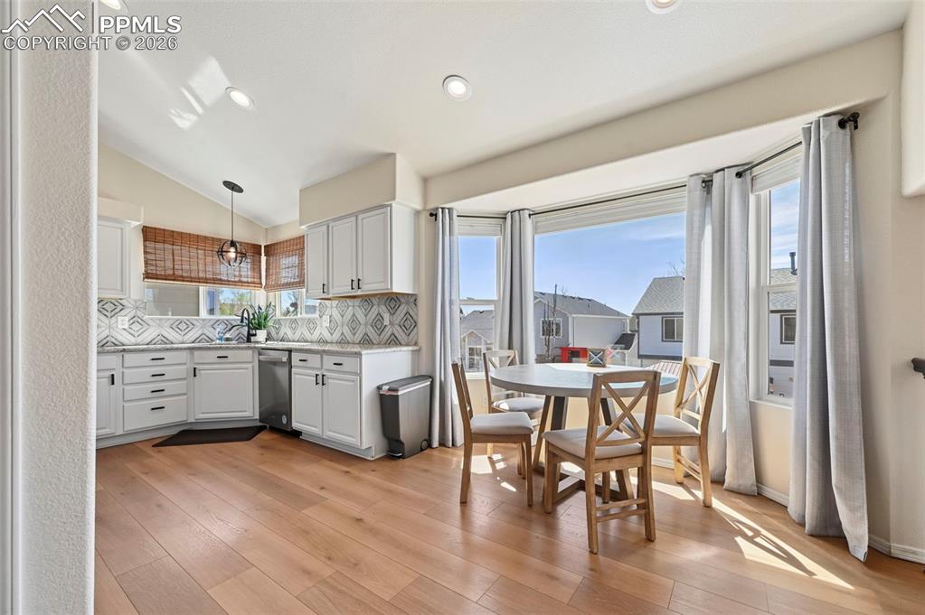 Image 9 of 45: The kitchen features white cabinetry with black hardware, and a patterned b