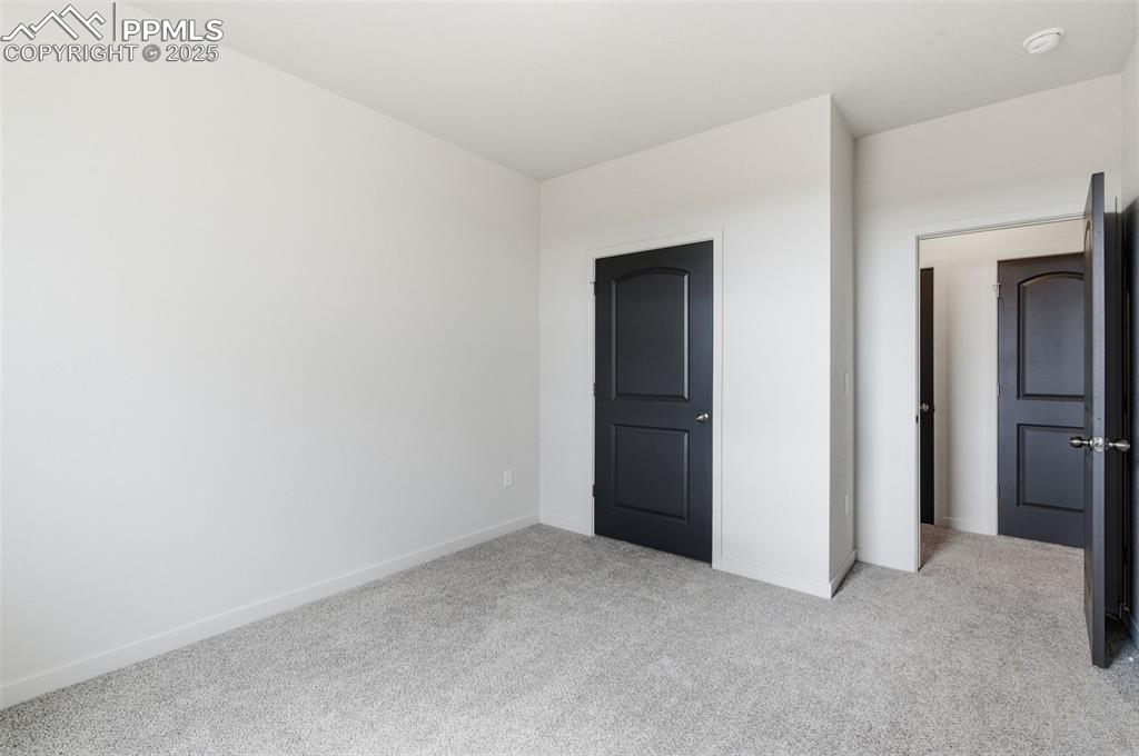 Image 16 of 24: Unfurnished bedroom with light colored carpet and baseboards