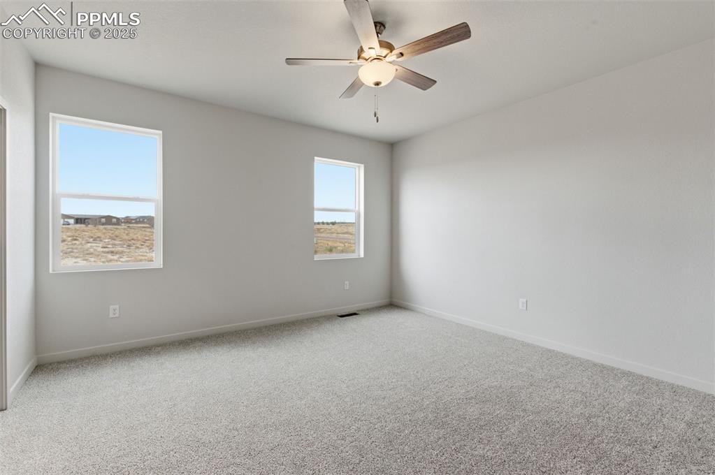 Image 17 of 24: Carpeted empty room featuring ceiling fan and baseboards