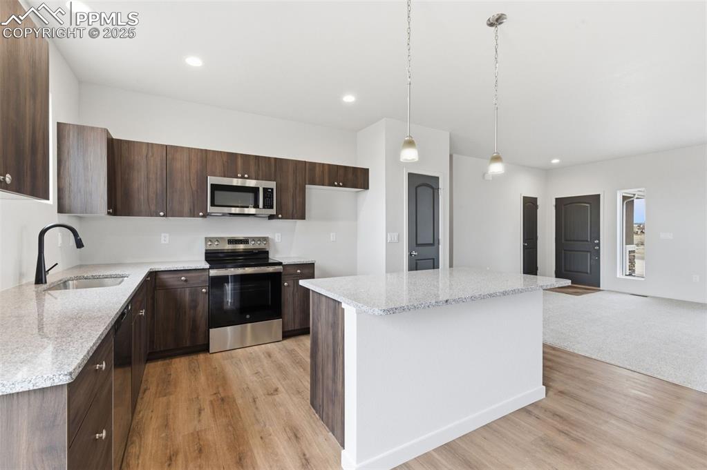 Image 7 of 24: Kitchen with light stone counters, stainless steel appliances, a kitchen is