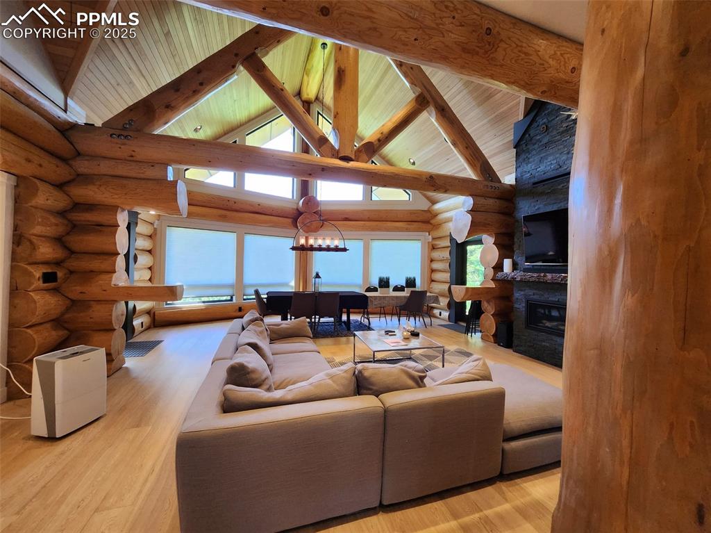 Image 16 of 17: Not the actual property -- Living area featuring a fireplace, a chandelier,