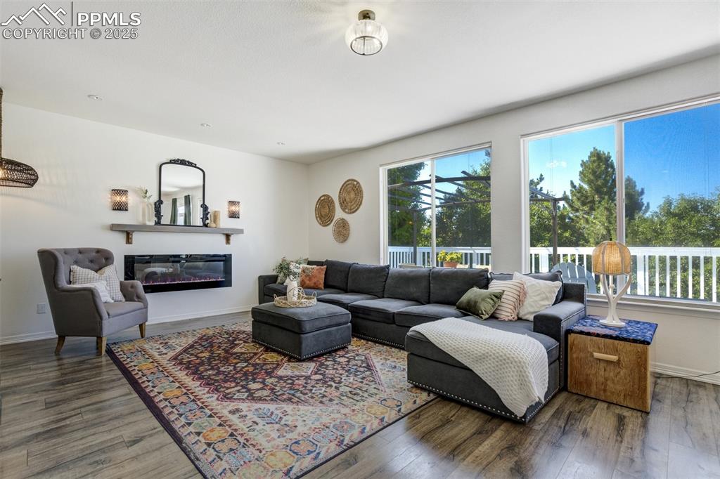 Image 13 of 50: Living room has a fireplace, ample windows, and room for the whole family. 