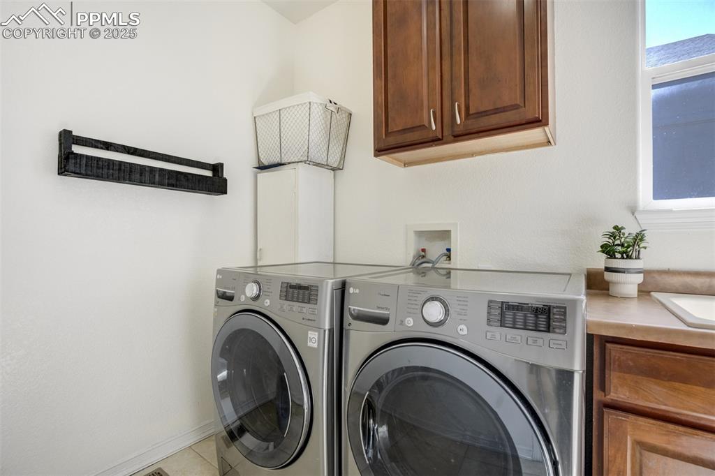 Image 24 of 50: Laundry room on the main level with a window & utility sink. 