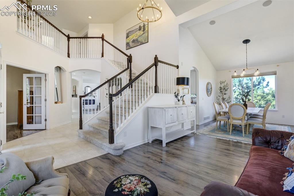 Image 4 of 50: Soaring ceilings as you enter the home with a living room & dining room tha