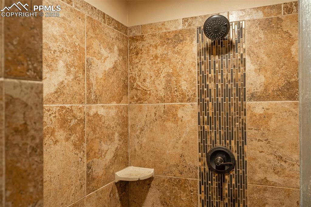 Image 42 of 50: Beautiful tile in the basement shower. 