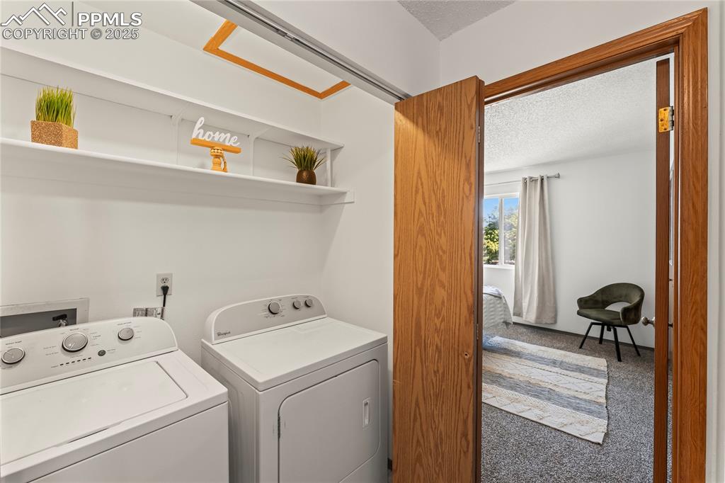Image 14 of 25: Washroom featuring carpet flooring, a textured ceiling, and washing machine