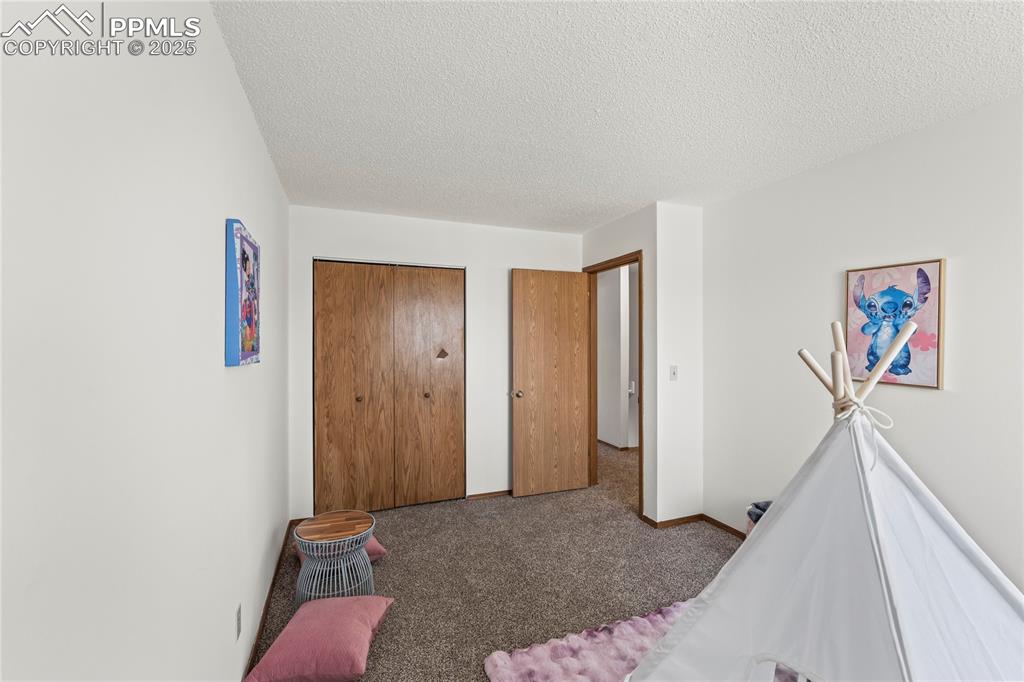 Image 18 of 25: Carpeted bedroom with a closet and a textured ceiling