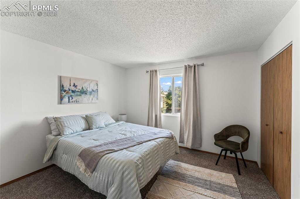 Image 19 of 25: Bedroom with carpet floors, a closet, and a textured ceiling