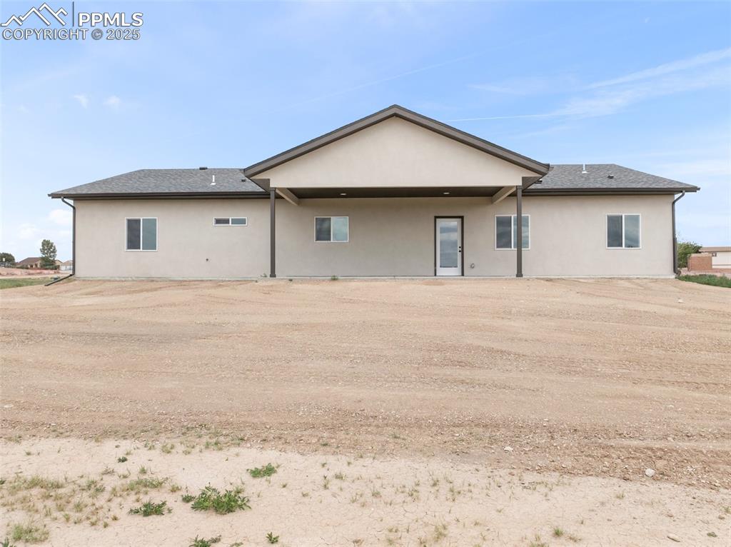 Image 31 of 38: Rear view of property featuring stucco siding, a patio area, and a shingled