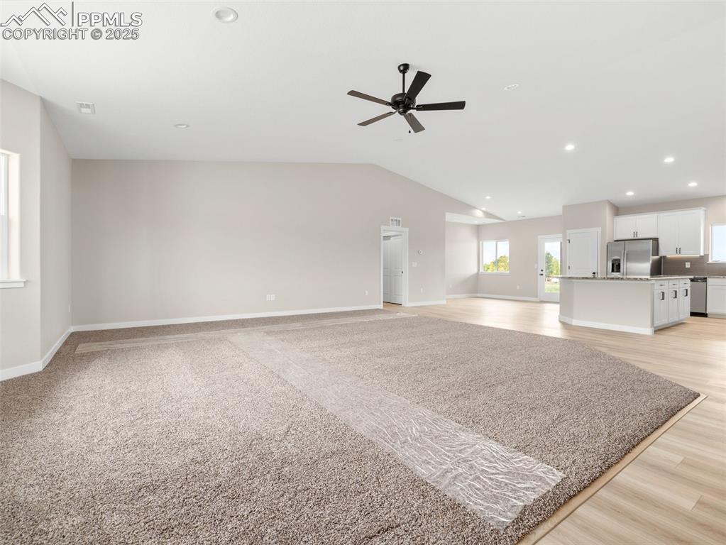 Image 4 of 38: Unfurnished living room with recessed lighting, vaulted ceiling, a ceiling