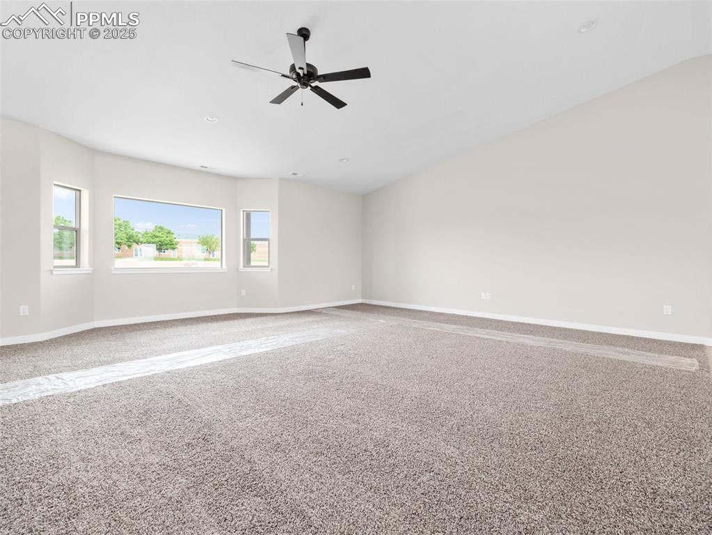 Image 5 of 38: Carpeted spare room featuring baseboards and ceiling fan