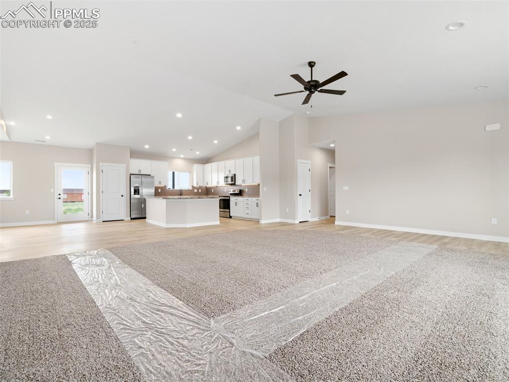 Image 7 of 38: Unfurnished living room featuring recessed lighting, vaulted ceiling, light