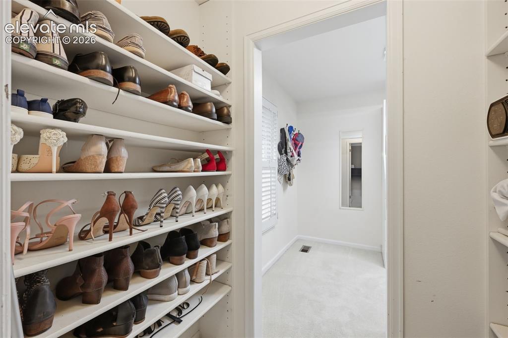Image 24 of 49: Shoe area of walk in closet