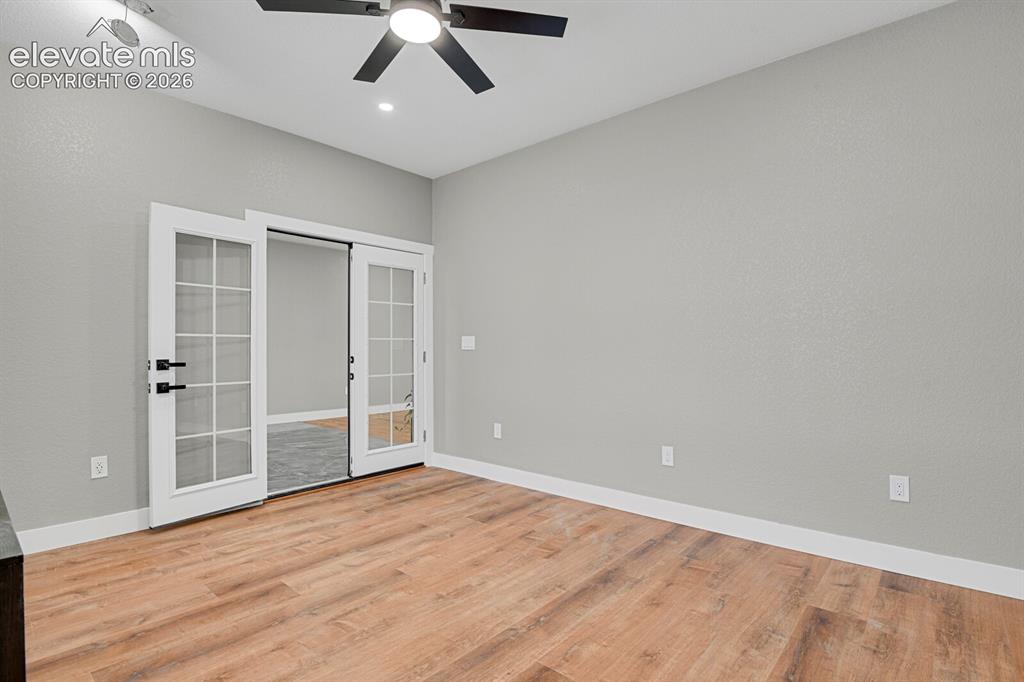 Image 10 of 49: Wood-finish flooring, white trim, and a ceiling fan with integrated lightin