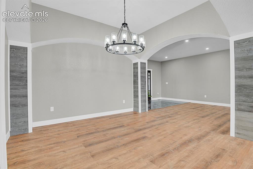 Image 12 of 49: Wood-finish flooring, recessed lighting, arched entryway, and a contemporar
