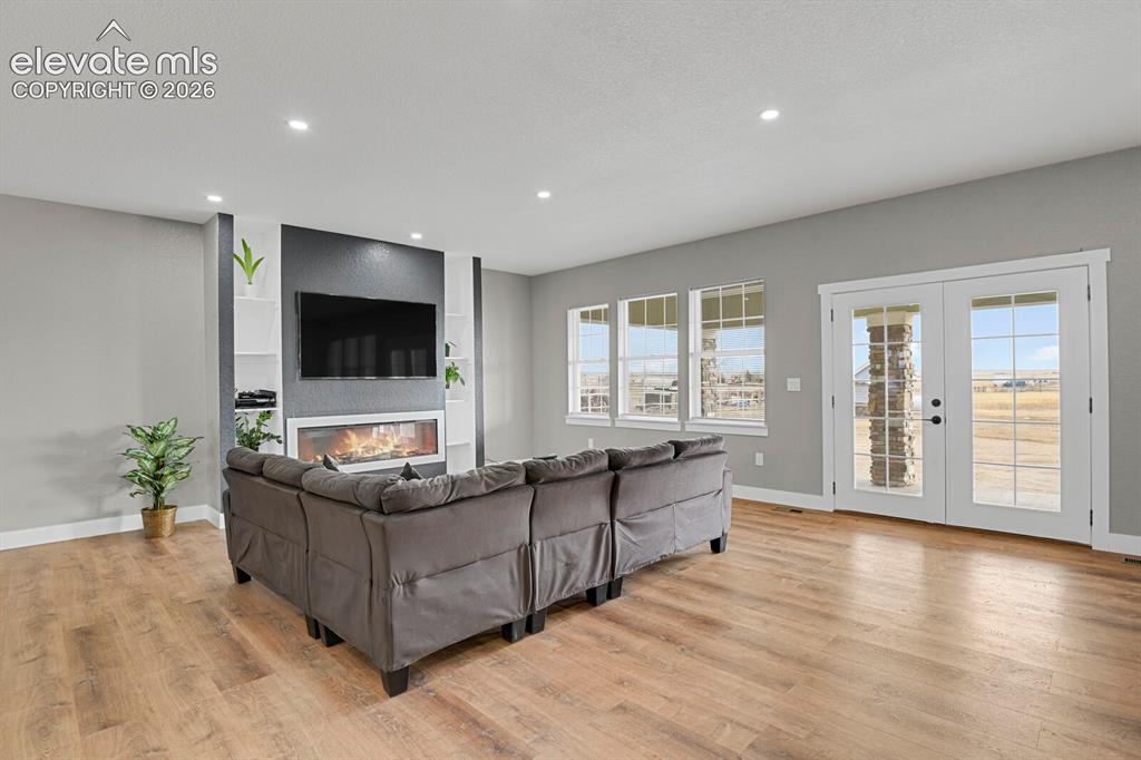 Image 13 of 49: Expansive living area featuring wood-finish flooring, recessed lighting, an
