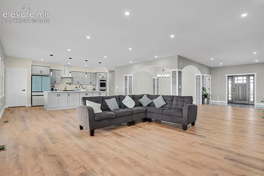 Image 15 of 49: Open-concept living area featuring wood-finish flooring, recessed lighting,