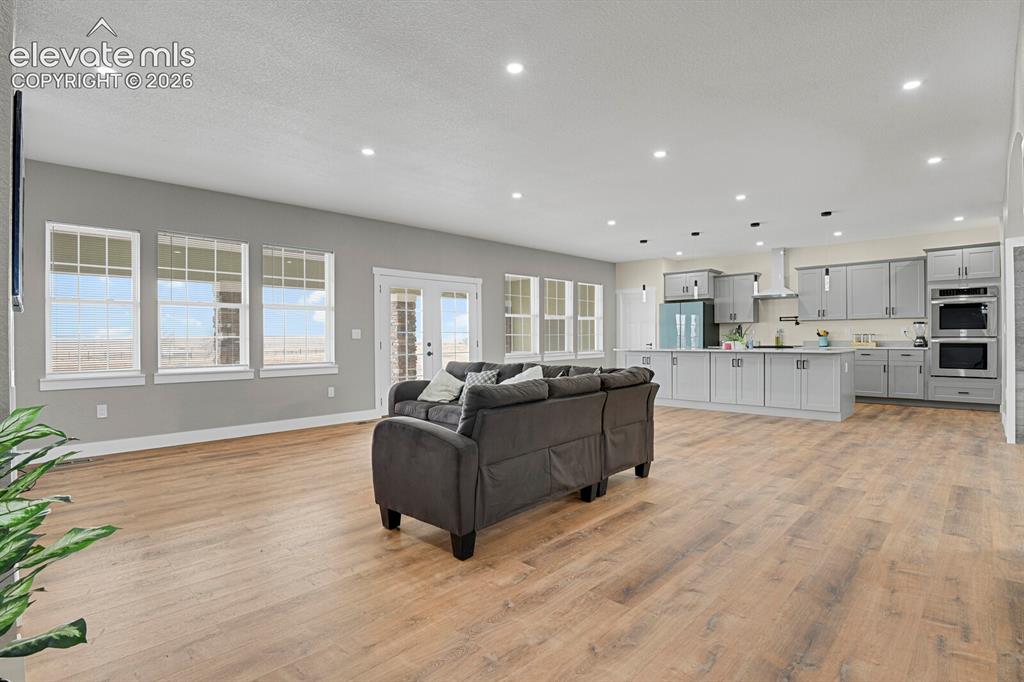 Image 16 of 49: Open-concept living space featuring wood-finish flooring, recessed lighting