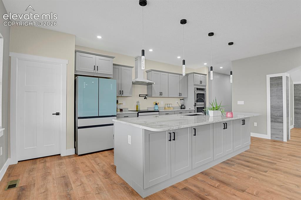 Image 18 of 49: Spacious kitchen featuring an expansive island with a stone-finish countert