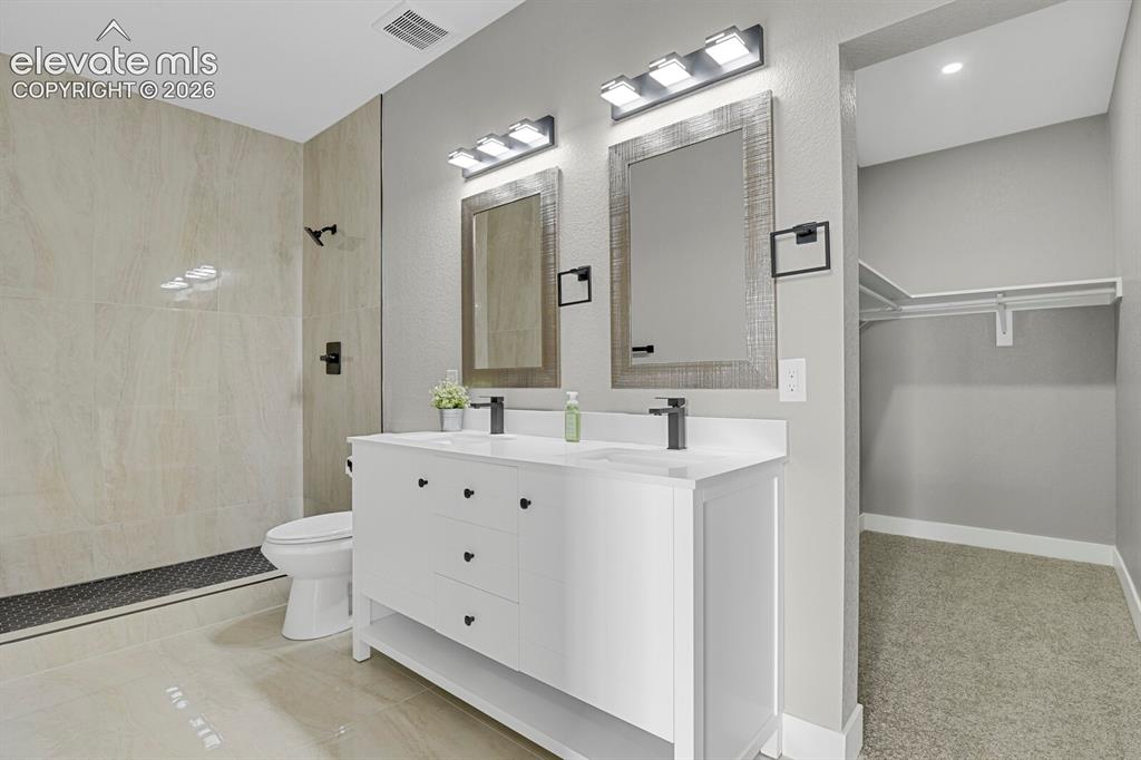 Image 23 of 49: Dual vanity with integrated sinks, contemporary matte black fixtures, full-