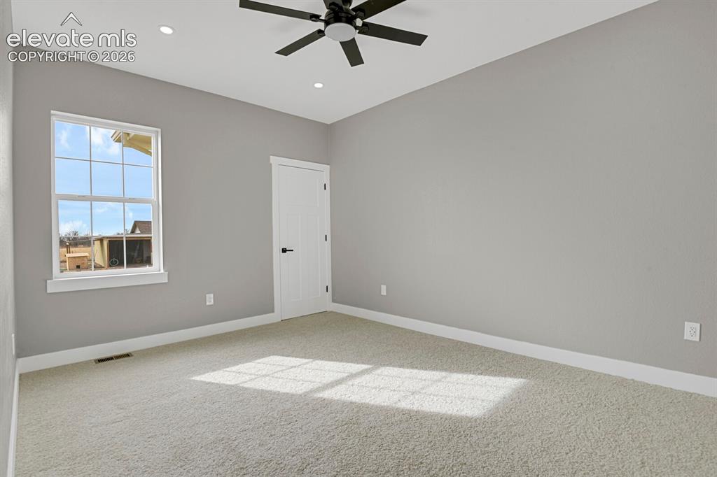 Image 24 of 49: Recessed lighting, ceiling fan, grid window, paneled door, and light-colore