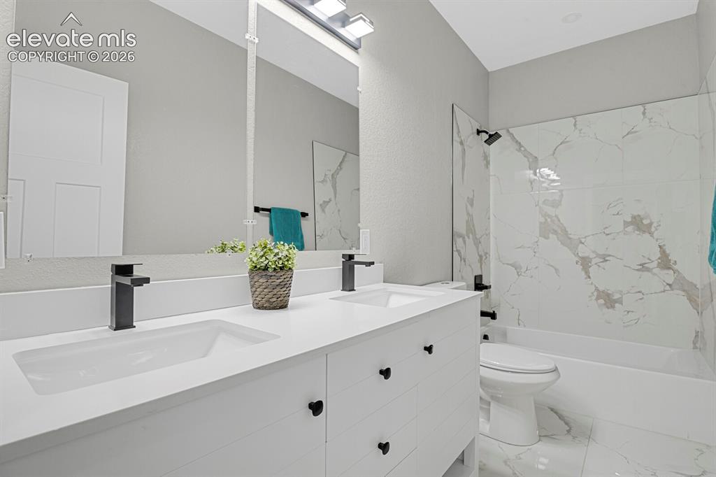 Image 25 of 49: Dual vanity with integrated sinks and matte black fixtures