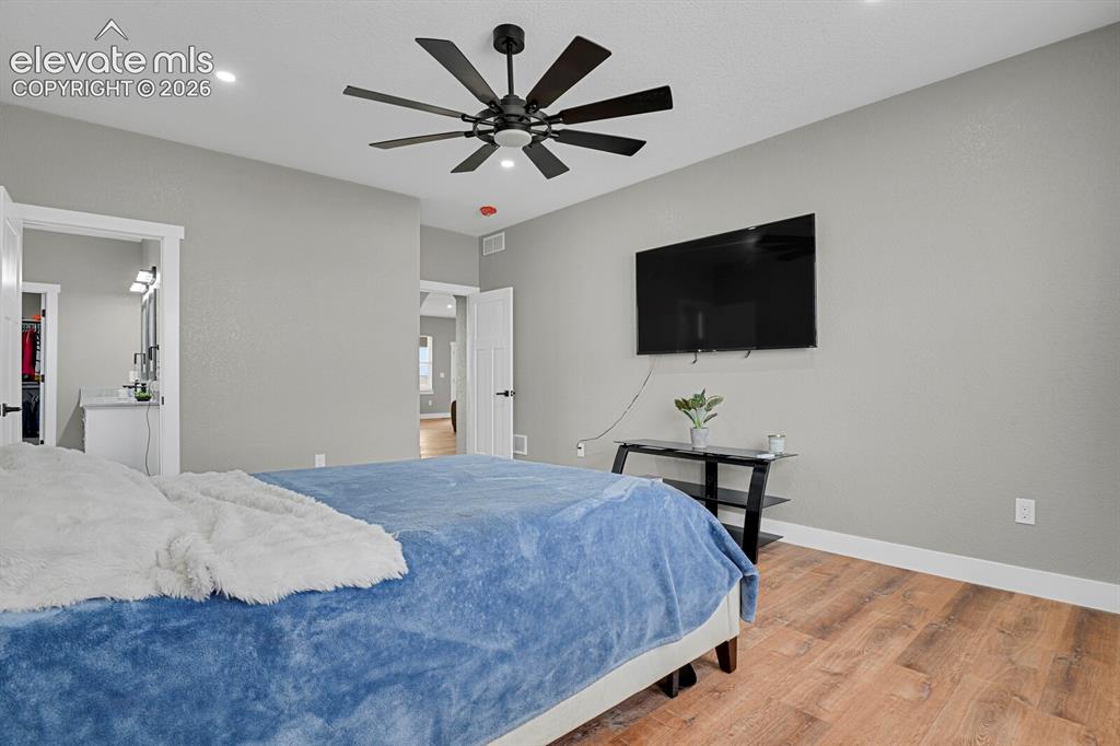 Image 30 of 49: Wood-finish flooring, recessed lighting, and a ceiling fan with integrated