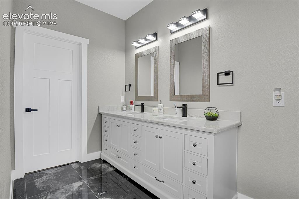 Image 31 of 49: Double vanity with a light-toned countertop, two integrated sinks, and indi