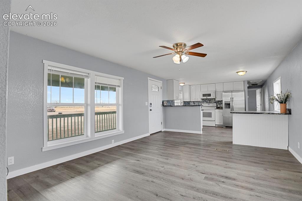 Image 36 of 49: Open-concept living space featuring wood-finish flooring, a ceiling fan, an