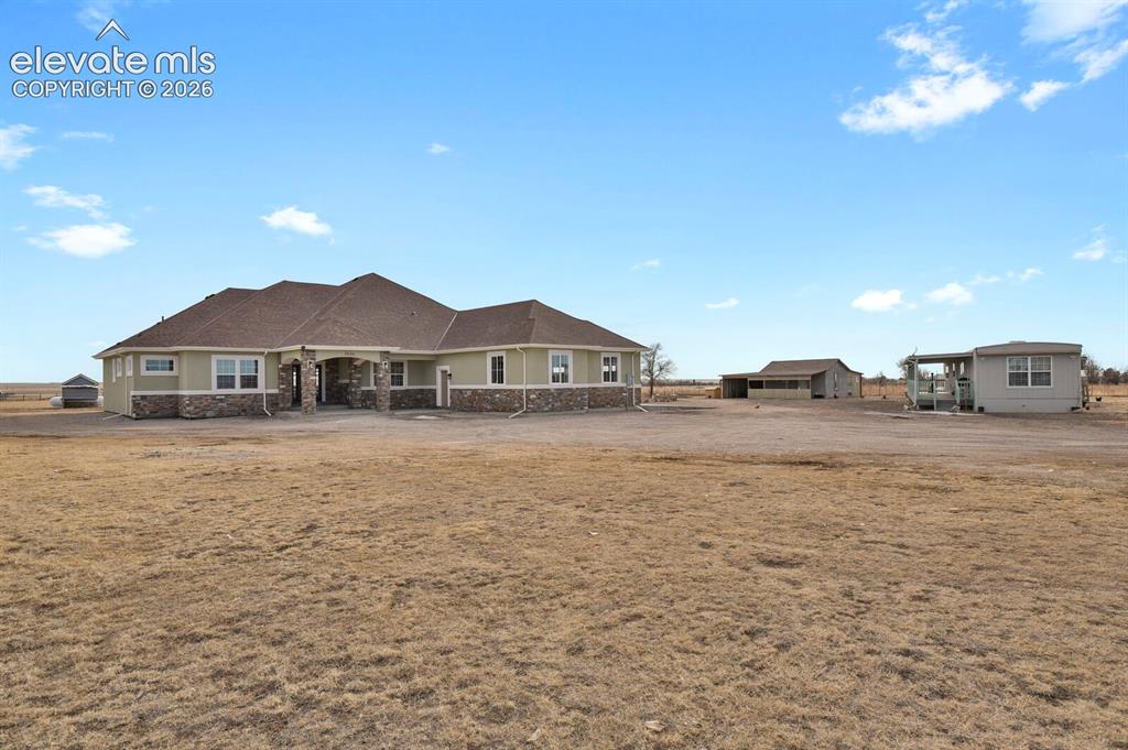 Image 4 of 49: Expansive property featuring a residence with a stone and siding exterior, 
