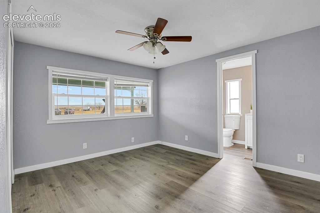Image 40 of 49: Wood-finish flooring, overhead ceiling fan with lighting, and multiple wind