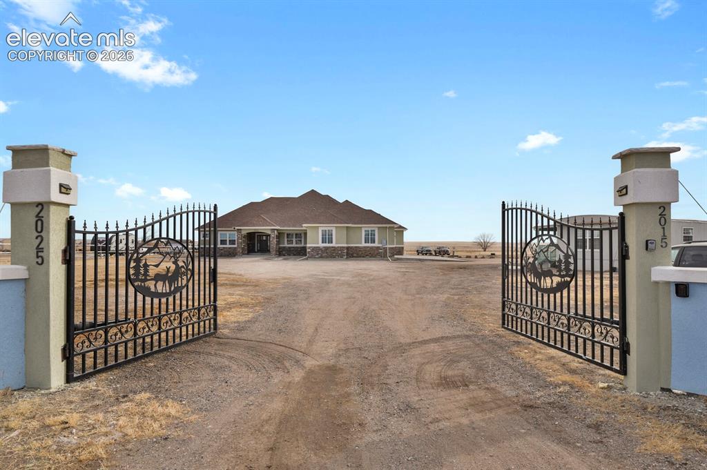 Image 5 of 49: Decorative wrought iron gates with integrated address numbers, flanked by s