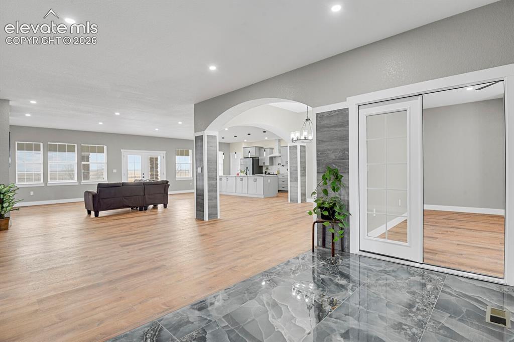 Image 8 of 49: Open-concept living space featuring wood-finish flooring, recessed lighting