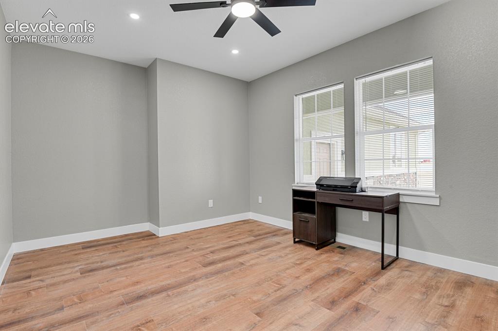 Image 9 of 49: Wood-finish flooring, recessed lighting, and a ceiling fan