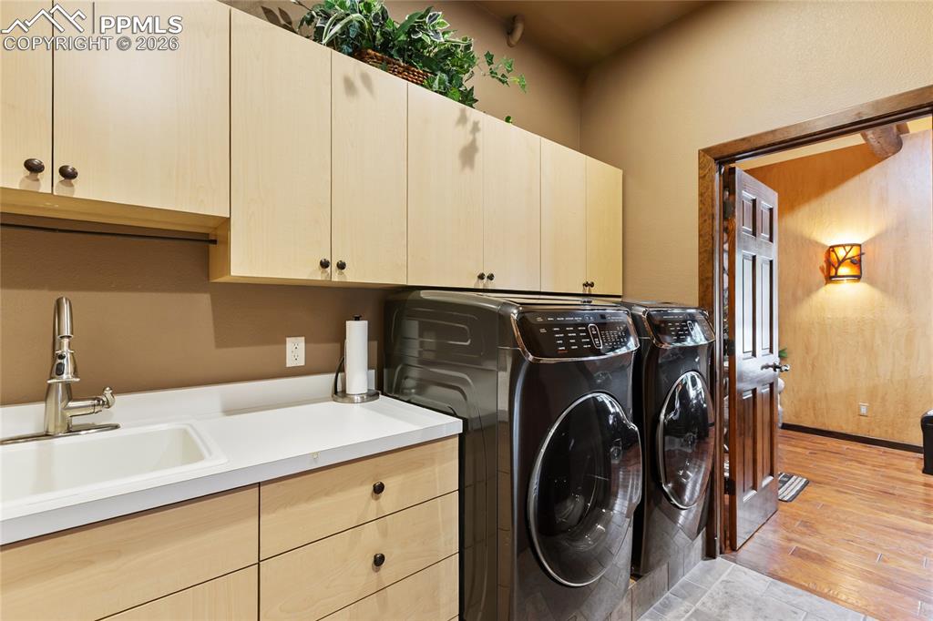 Image 13 of 36: A main level laundry with a sink, a walk out to the back walkway and a ful