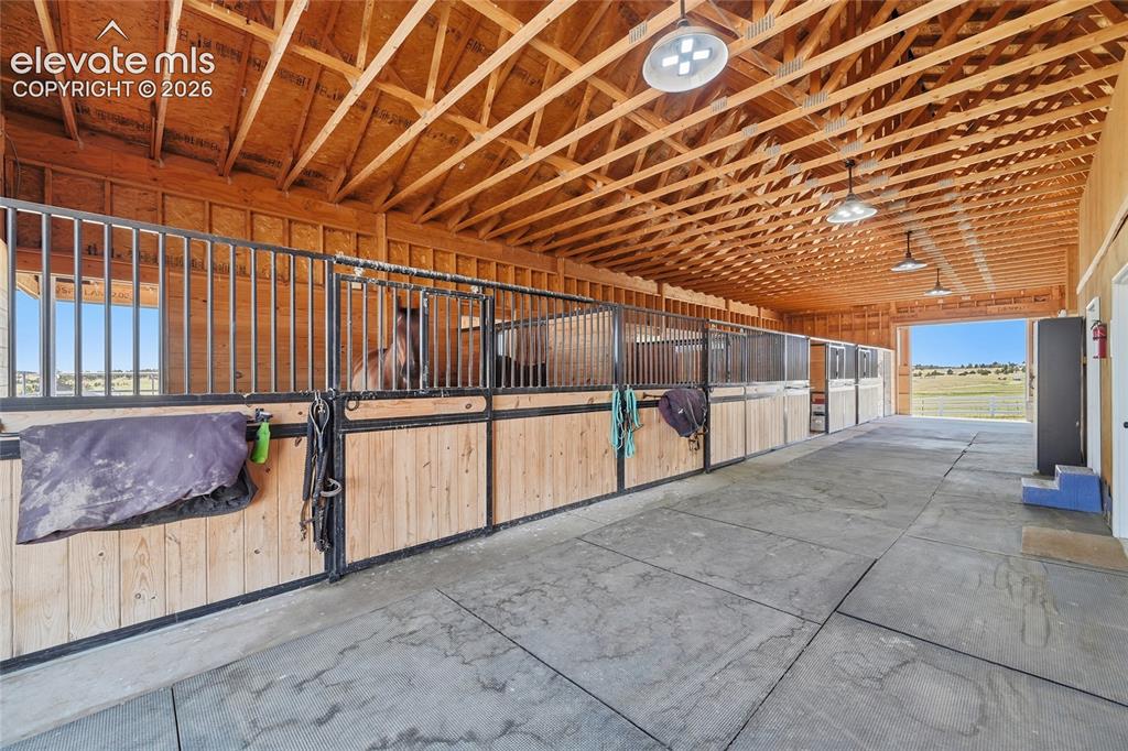 Image 3 of 43: Interior barn featuring spacious barn aisle and multiple horse stalls