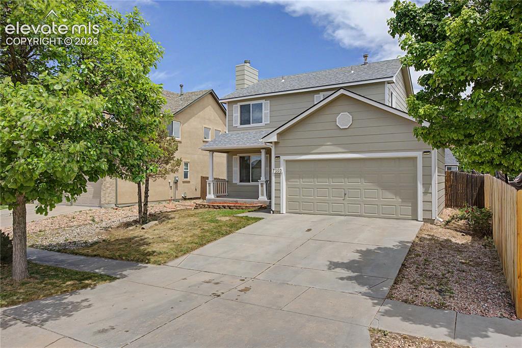 Caption: Two-story residence featuring light-toned siding and a prominent two-car garage