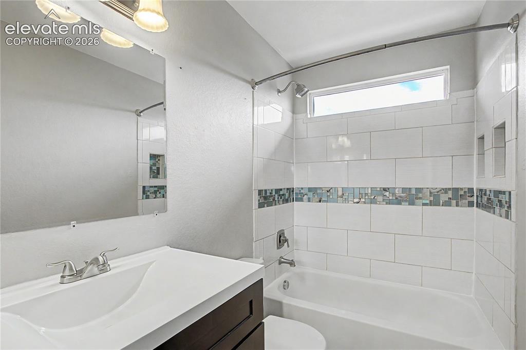 Image 13 of 18: Full bathroom featuring a tub/shower combination with white subway tile and