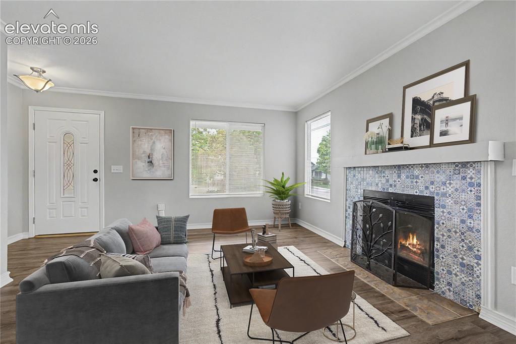 Image 2 of 18: Living area featuring wood-finish flooring, a white paneled entry door with