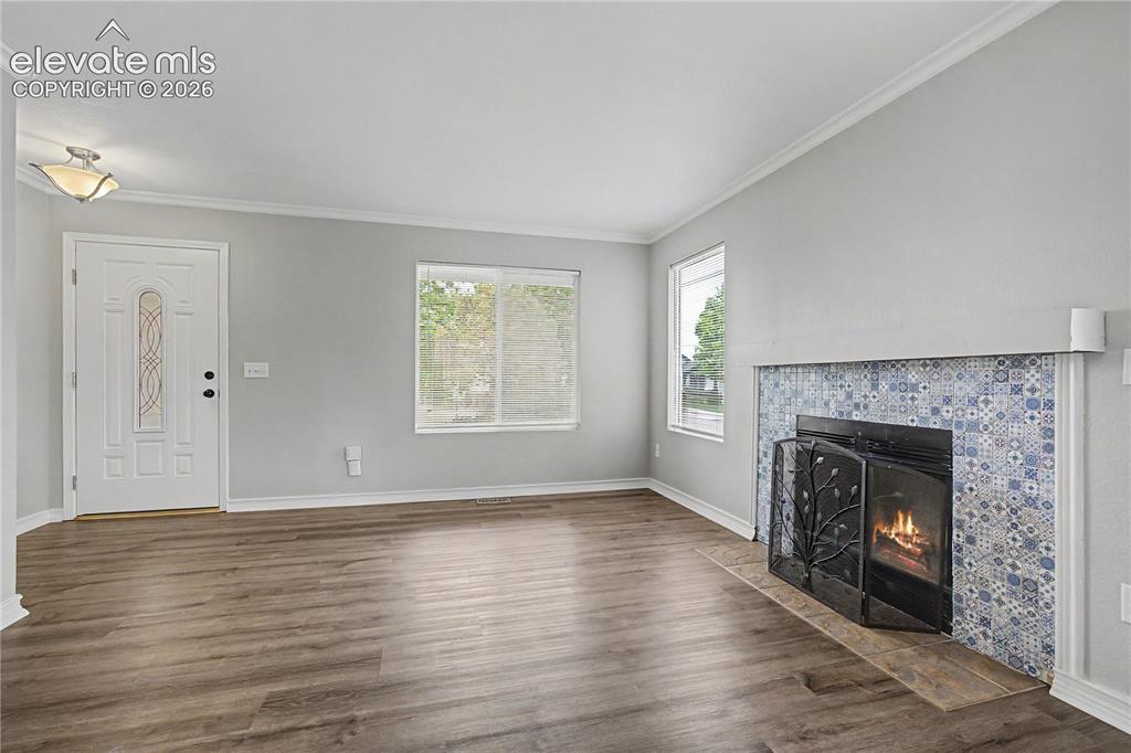 Image 3 of 18: Living area featuring wood-finish flooring, a white paneled entry door with