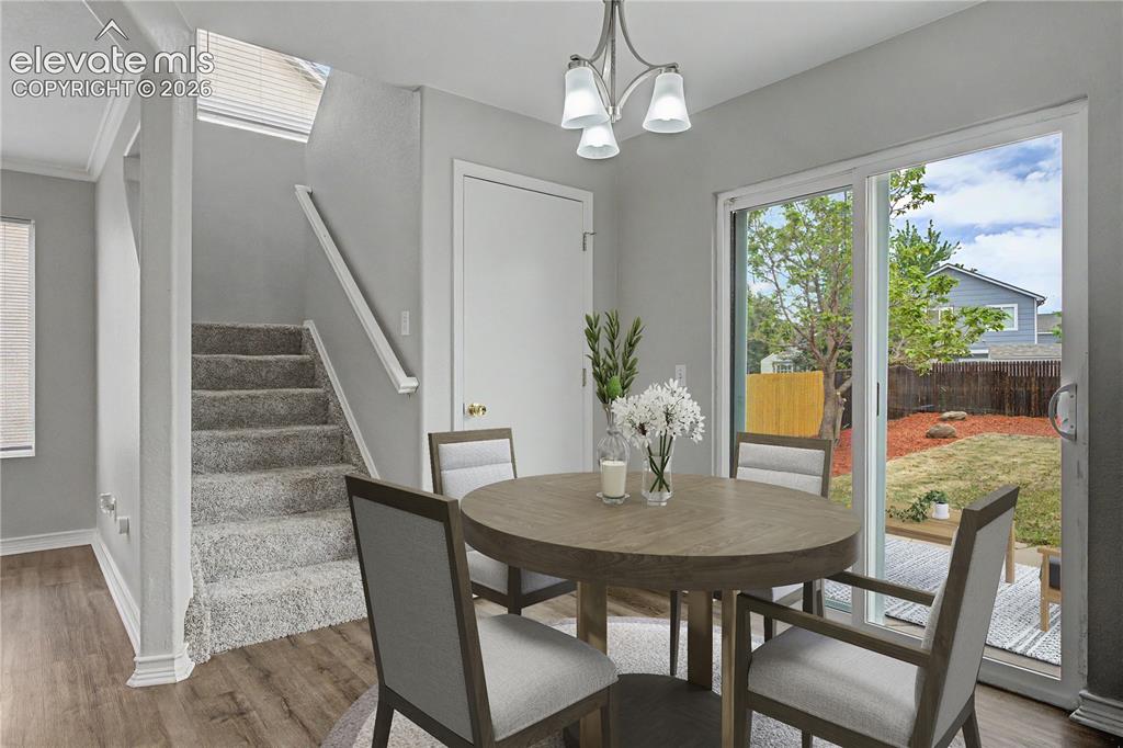 Image 4 of 18: Dining area with wood-finish flooring, a sliding glass door to the backyard