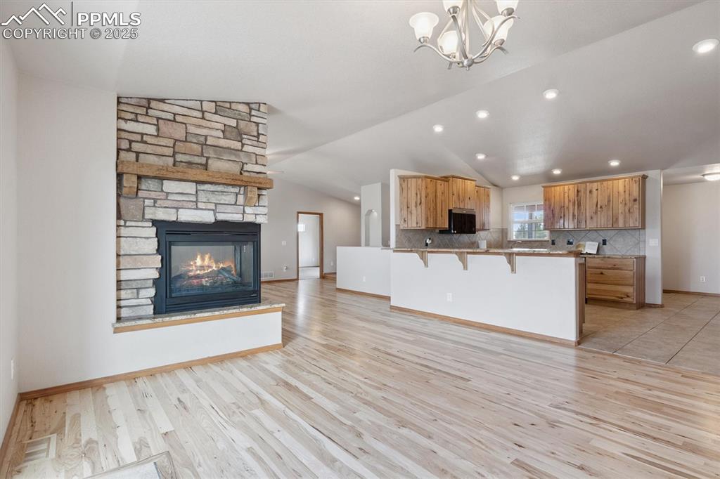 Image 14 of 42: Dining room with 3-sided fireplace looking towards kitchen 