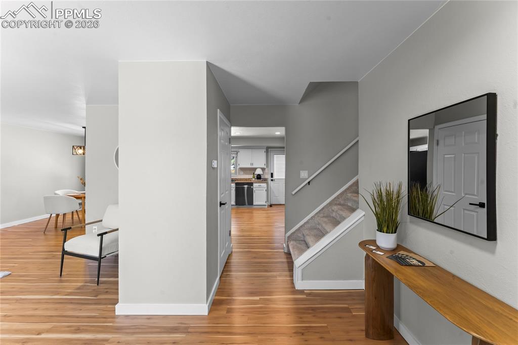 Image 17 of 50: Entryway featuring wood-finish flooring, light gray walls, and white basebo