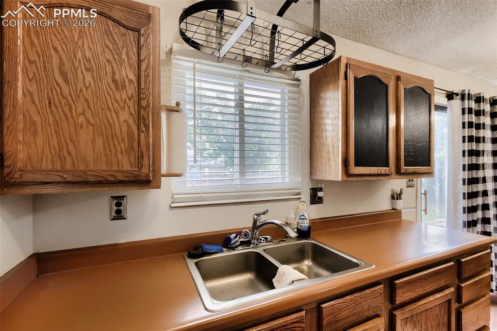 Image 11 of 28: Living area featuring wood-finish flooring, a large window with horizontal