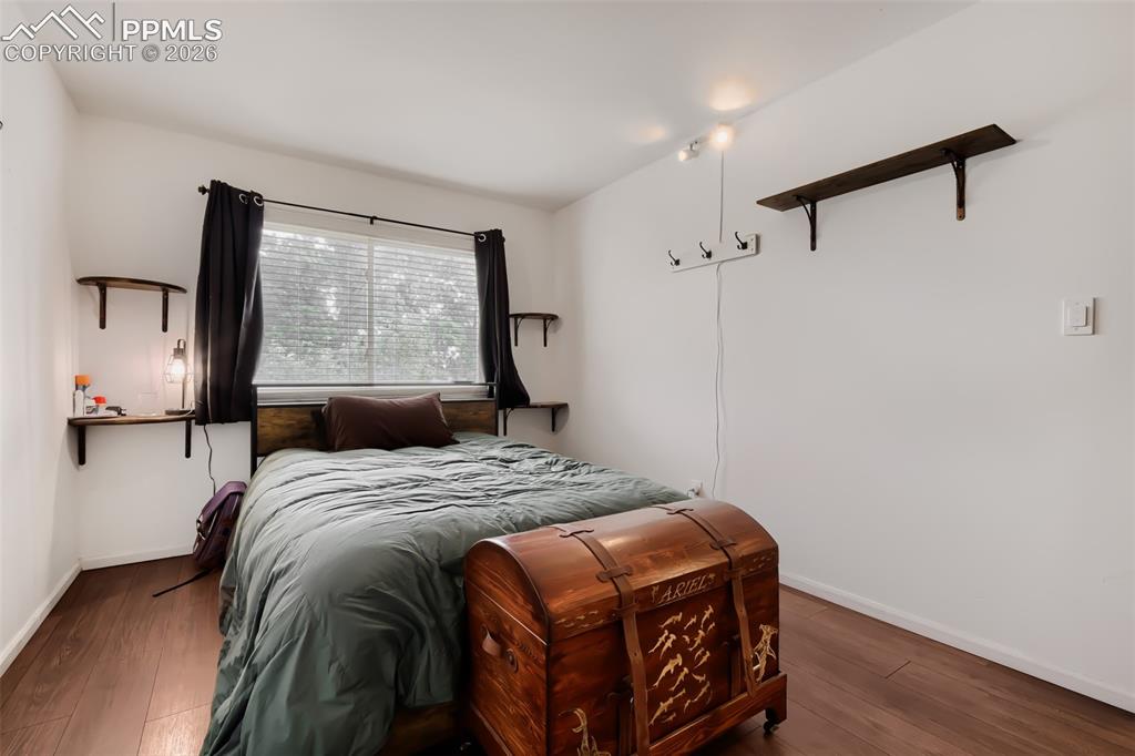Image 18 of 28: Living area featuring wood-finish flooring, built-in shelving, and a wall-m